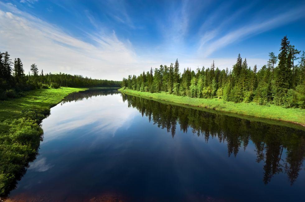 The river with a quiet current and clouds reflected in it, Russia, Yakutia.