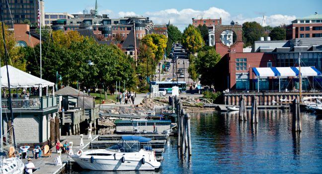 Burlington, VT, USA - September 30, 2013: People gather to watch the boats along the water at the Burlington Marina while pedestrians walk the Island Line Trail along the waterfront in the sun.