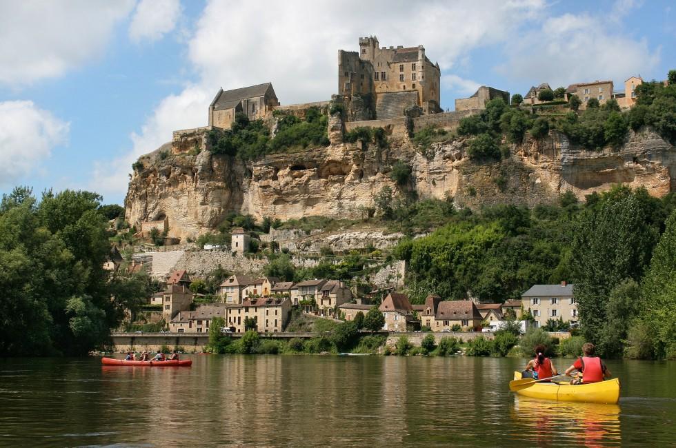 Beautiful landscape with tourists kayaking on river Dordogne and Ch&#xc3;&#xa2;teau de Beynac in the background as seen in Beynac-et-Cazenac, Southern France