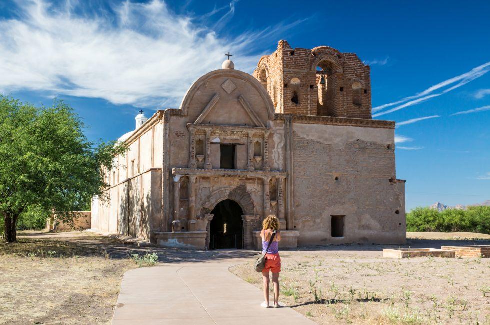 A woman visitor take a picture of the preserved Spanish mission at Tumacacori, Arizona.
