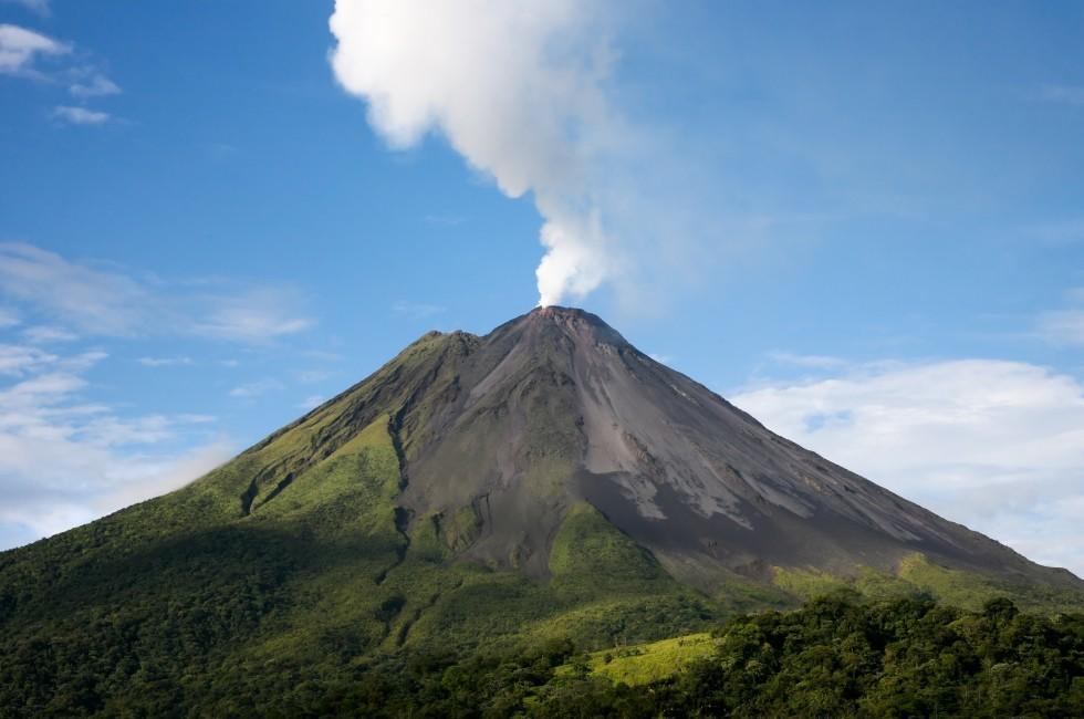 Arenal volcano in costa rica with a plume of smoke.